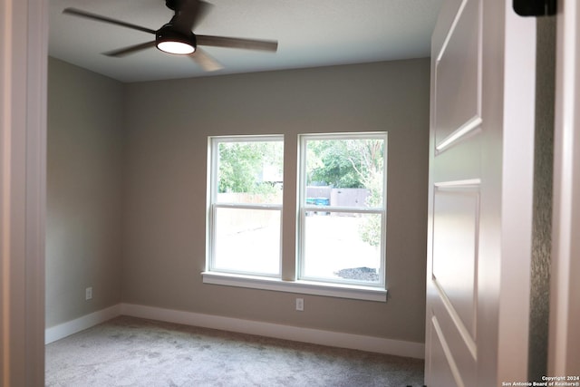 spare room with ceiling fan and light colored carpet