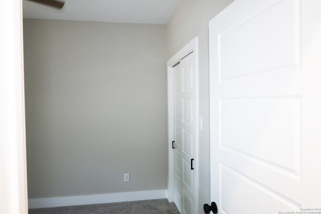 laundry area featuring dark colored carpet