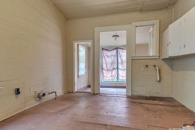 washroom featuring light wood-type flooring and wooden walls