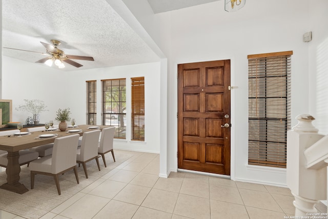 foyer featuring ceiling fan, a textured ceiling, and light tile patterned floors