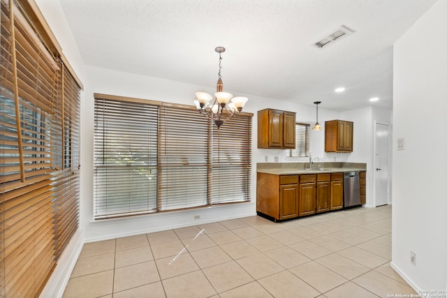 kitchen with light tile patterned floors, sink, dishwasher, hanging light fixtures, and a textured ceiling