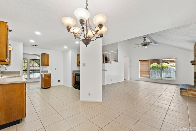 kitchen featuring ceiling fan with notable chandelier, decorative light fixtures, sink, light tile patterned floors, and a textured ceiling