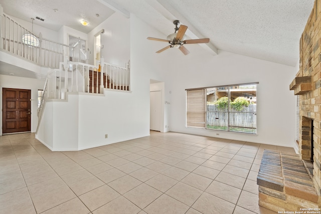 unfurnished living room featuring light tile patterned flooring, a fireplace, beam ceiling, and a textured ceiling