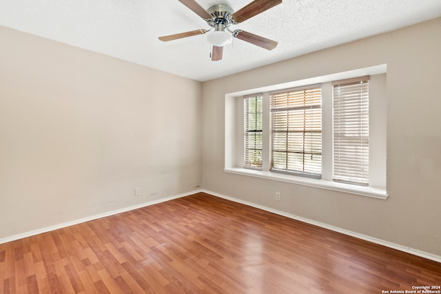 empty room with hardwood / wood-style flooring, ceiling fan, and a textured ceiling