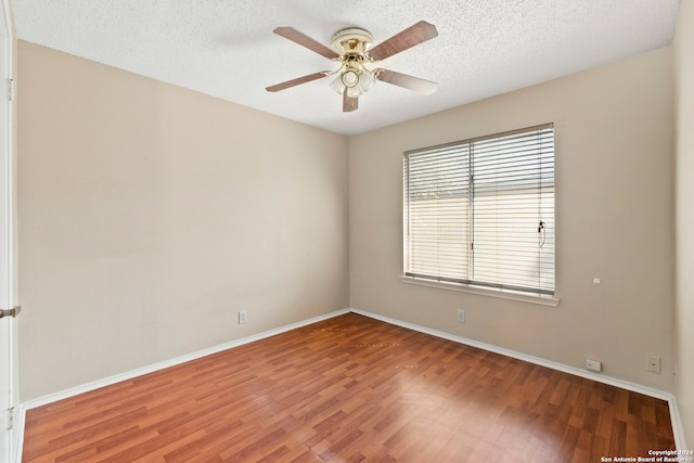 empty room featuring ceiling fan, wood-type flooring, and a textured ceiling