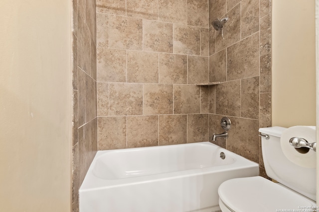 bathroom with tiled shower / bath combo and toilet