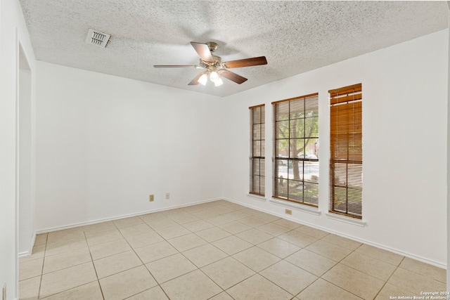 tiled empty room with a textured ceiling and ceiling fan