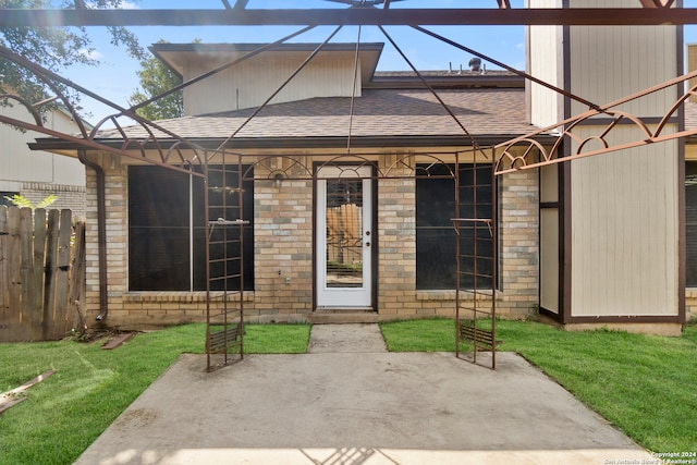 entrance to property with a patio and a lawn