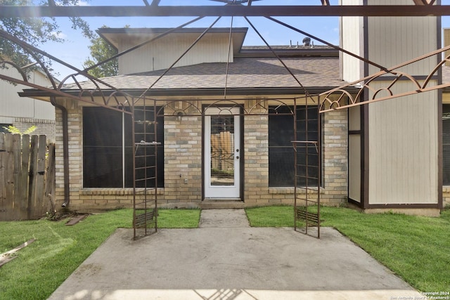 doorway to property with a patio area and a lawn