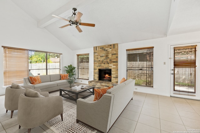 tiled living room with ceiling fan, beam ceiling, high vaulted ceiling, and a brick fireplace