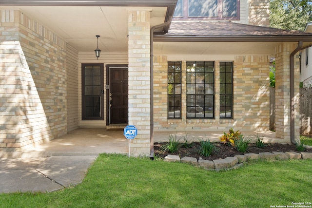 view of exterior entry with a lawn