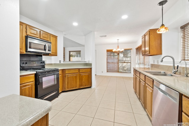 kitchen featuring pendant lighting, stainless steel appliances, sink, and light tile patterned floors