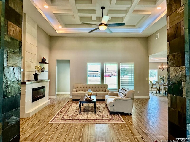 living room with a towering ceiling, beam ceiling, and coffered ceiling