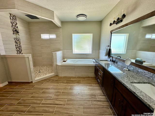 bathroom featuring independent shower and bath, a textured ceiling, tile patterned flooring, and dual bowl vanity