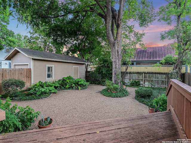 yard at dusk featuring a deck