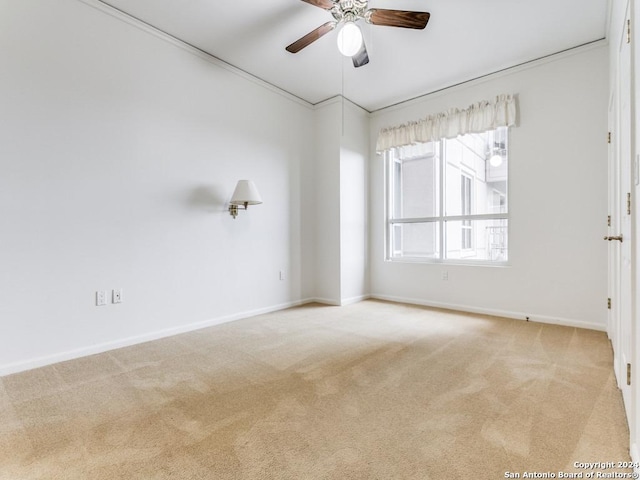 carpeted empty room with ceiling fan and crown molding