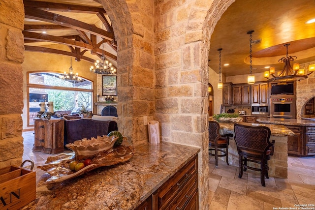 kitchen featuring an inviting chandelier, hanging light fixtures, stainless steel oven, and stone counters