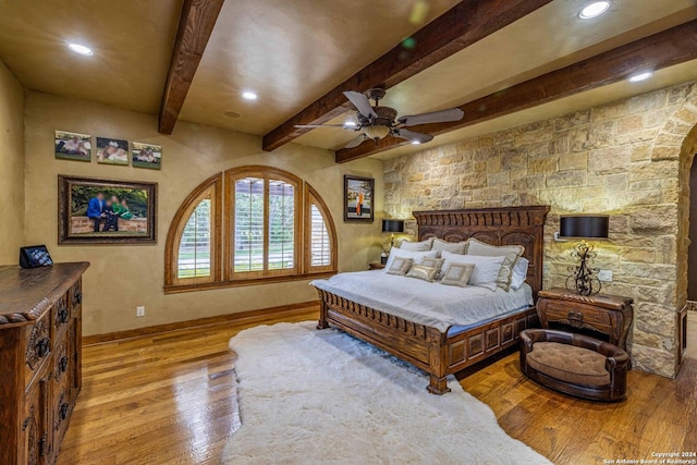 bedroom with ceiling fan, light hardwood / wood-style flooring, and beamed ceiling