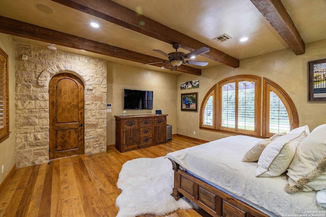 bedroom featuring beam ceiling, light hardwood / wood-style flooring, and ceiling fan