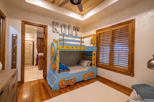 bedroom featuring hardwood / wood-style floors, ceiling fan, and a tray ceiling