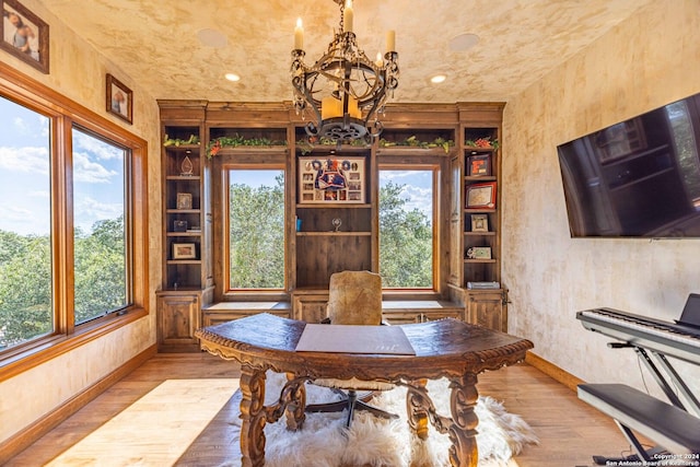 interior space with a healthy amount of sunlight, an inviting chandelier, and light hardwood / wood-style flooring