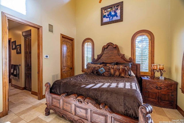 bedroom with multiple windows and a towering ceiling