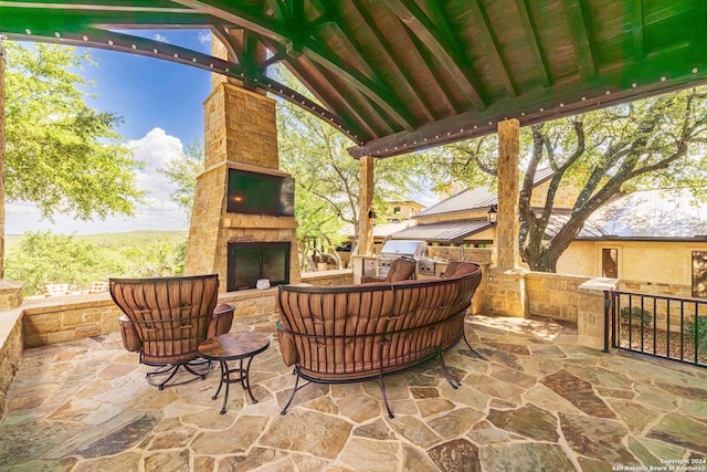 view of patio with grilling area, area for grilling, and an outdoor stone fireplace