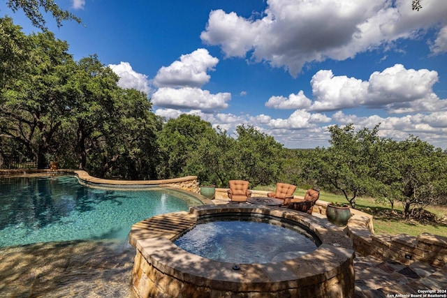 view of pool featuring an in ground hot tub