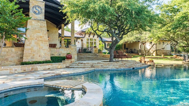 view of pool with a patio and an in ground hot tub