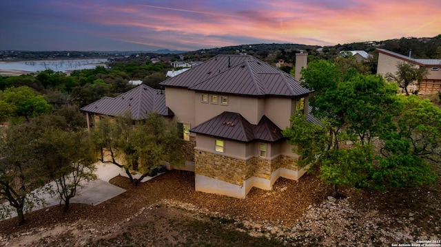 aerial view at dusk featuring a water view