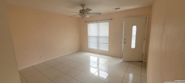 entryway with visible vents, ceiling fan, baseboards, and light tile patterned floors