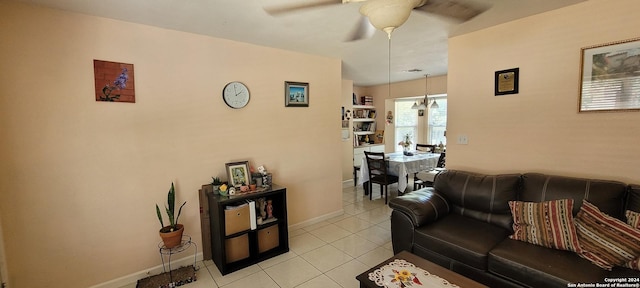 living area featuring a ceiling fan, baseboards, and light tile patterned floors