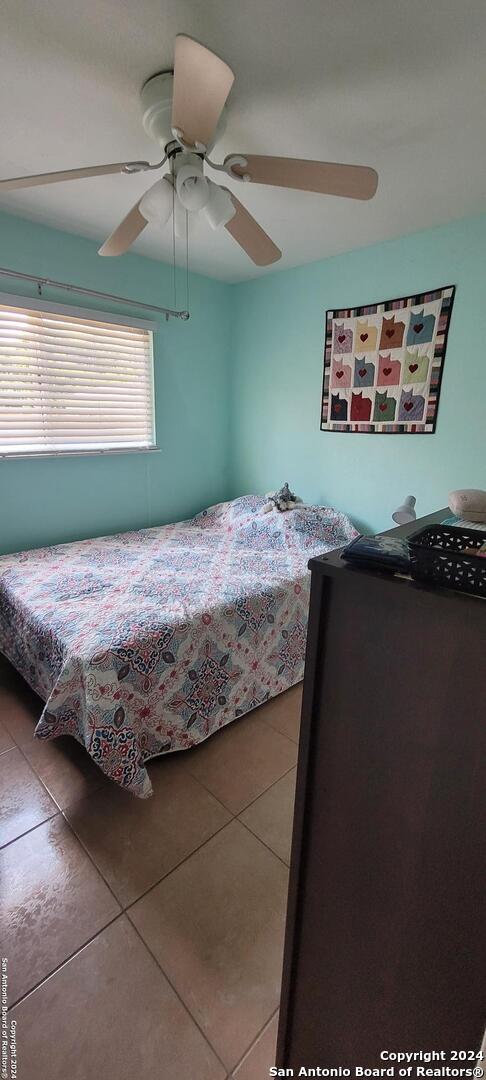 bedroom with a ceiling fan and tile patterned floors