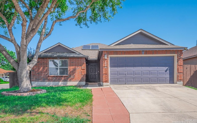 single story home with solar panels and a garage