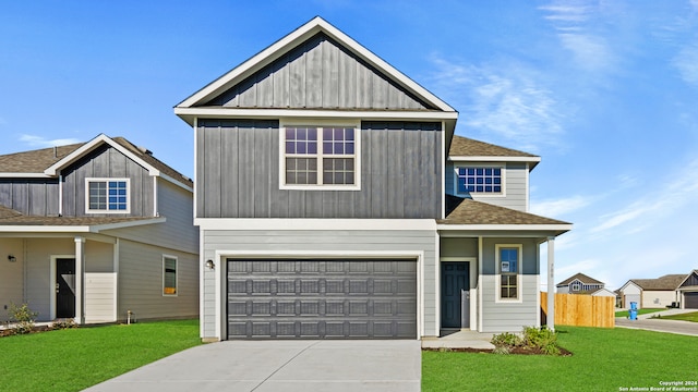 view of front of home with driveway, a shingled roof, a front yard, and fence