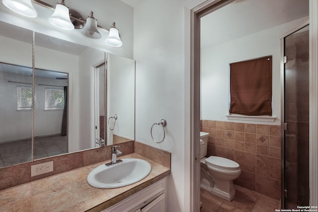 bathroom with vanity, toilet, and tile walls