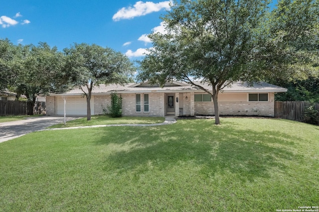 ranch-style house featuring a garage and a front yard