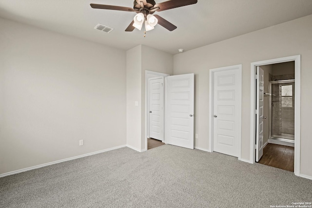 unfurnished bedroom with ceiling fan, a closet, dark carpet, and connected bathroom