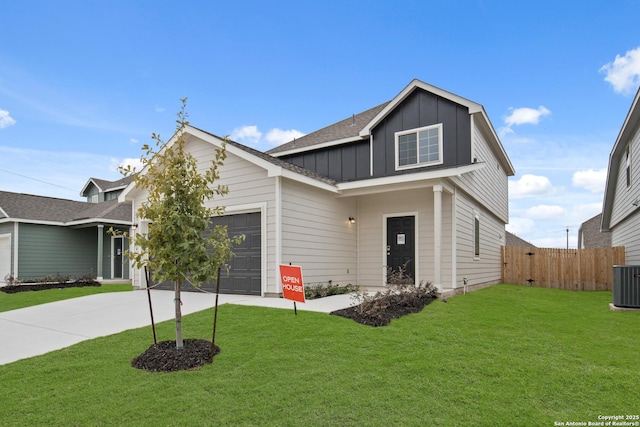 view of front of house with a front yard, a garage, and cooling unit