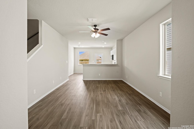 unfurnished living room with ceiling fan and dark hardwood / wood-style flooring