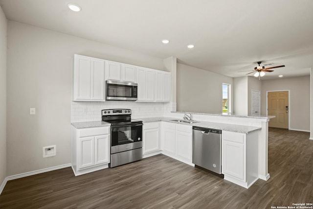 kitchen with white cabinets, kitchen peninsula, appliances with stainless steel finishes, and sink