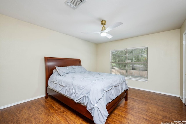 bedroom with dark hardwood / wood-style flooring and ceiling fan