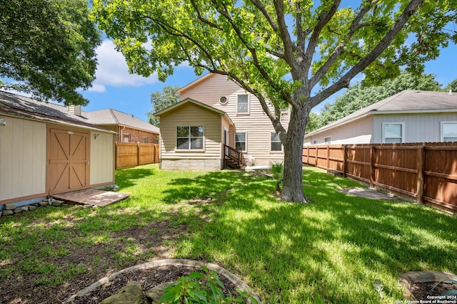 rear view of property with a yard and a storage shed