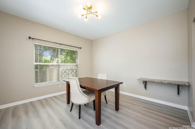 dining space featuring wood-type flooring and a chandelier