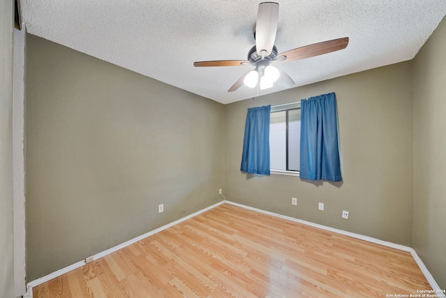 empty room with a textured ceiling, hardwood / wood-style floors, and ceiling fan