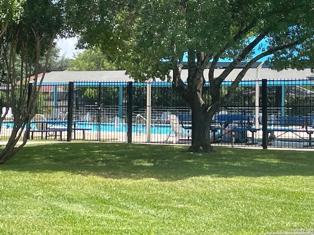 view of swimming pool featuring a yard