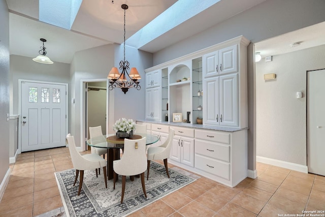 dining room with light tile patterned flooring, a skylight, and built in shelves