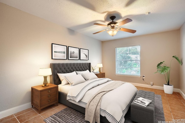 bedroom with a textured ceiling, ceiling fan, and light tile patterned floors