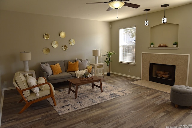 living room featuring a fireplace, wood-type flooring, and ceiling fan