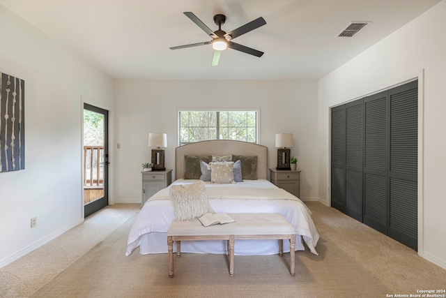 carpeted bedroom with multiple windows, ceiling fan, and a closet